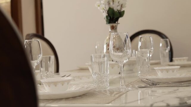 Cinematic video of a dining table with wine glass and other cutlery 