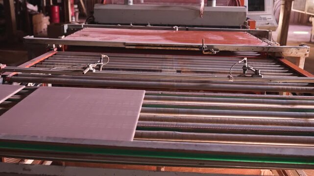 Ceramic Tiles Exiting Press Machine on Conveyor Belt in Factory