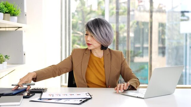 Business woman working in office checking documents.Accounting manager executive  reading paper file financial report, tax invoice.