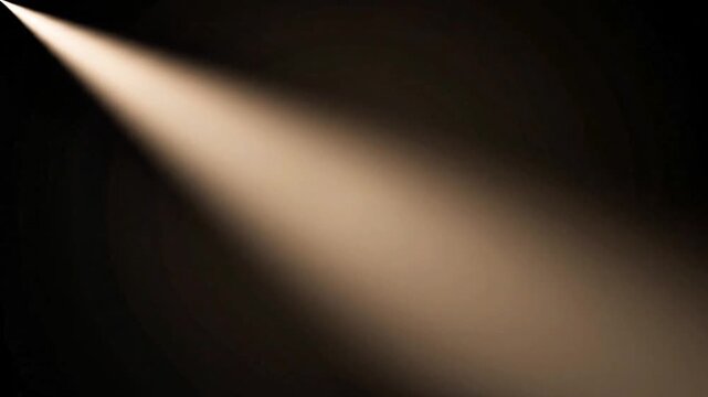 Dramatic warm spotlight beam shining in the dark