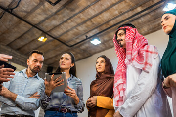 Fototapeta premium Professional greeting between an Arab male executive and his corporate colleagues. Handshake in a bright office setting representing international business relations