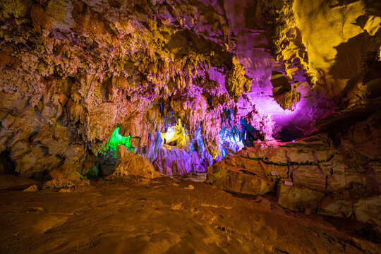 Beautiful limestone cave in Laos with illuminated pathways and richly textured rock formations creating a mystical atmosphere. Magical Cave Lighting Scene inside Tham Nang Ene Lao