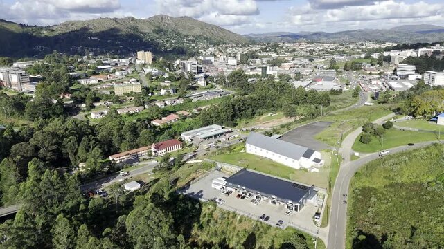Drone orbits left over neighborhood to the west of downtown Mbabane, Eswatini in the late afternoon