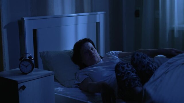 Elderly woman getting out of bed at night to use bathroom or wake early