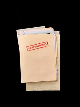 Top secret file folder with documents inside on dark background. Concept of confidential information, data leak, corporate secrets, investigation and security breach.