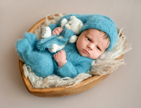 Newborn Baby In Wooden Bowl During A Photoshoot With A Newborn Photographer