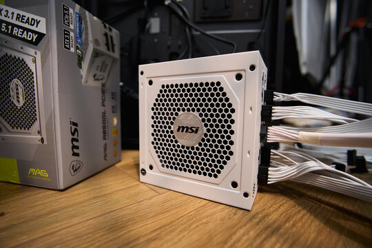 Tyumen, Russia-February 15, 2026: MSI power supply unit is shown on a wooden surface as part of the assembly of a personal computer