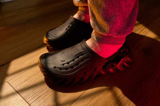 Tyumen, Russia-February 15, 2026: Crocs Echo Clog shoes worn indoors on a wooden floor during evening light
