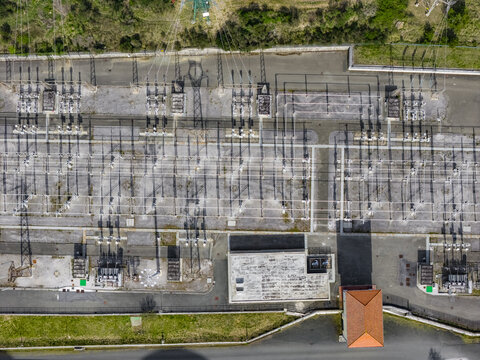 Larderello, Italy - 10 April 2026: Aerial view of the Enel Green Power geothermal power plant infrastructure with electrical transformers, power lines, and industrial buildings.