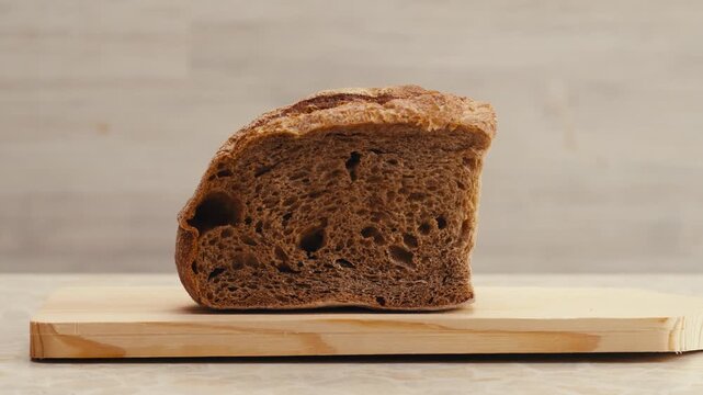 Black rye bread close up, dark brown sliced loaf, borodinsky slavic food, square slices with coriander on white background