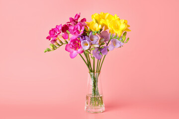 Obraz premium Beautiful freesia flowers in vase on pink background