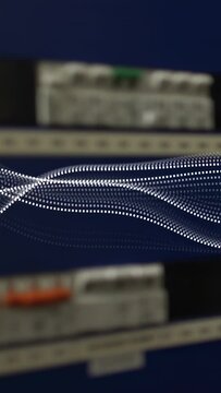 Vertical video: Play, dotted wave undulating and settling on DIN rail panel for electrical testing