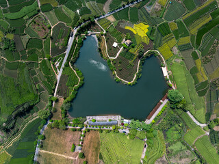 Fototapeta premium Aerial view of terraced fields surrounding a lake in a rural ecological landscape