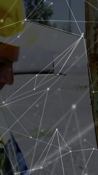 Vertical video: Nodes appearing sparking worker inspecting metal beam, using tablet, logging issues