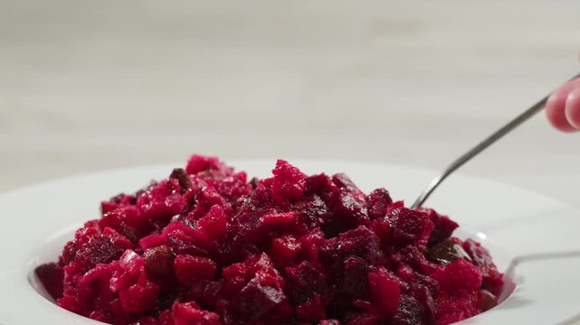 Russian beetroot vinaigrette salad with green peas, boiled vegetables and dill, close up in restaurant. 