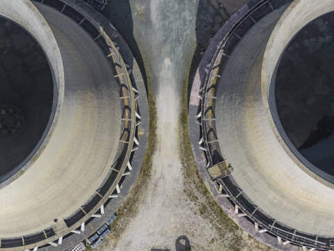 Larderello, Italy - 10 April 2026: Aerial view of Enel Green Power - Centrale Geotermica di Larderello showing the top-down perspective of two massive cooling towers and industrial grounds.