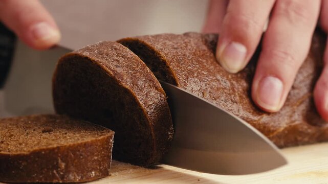 Black rye bread close up, dark brown sliced loaf, borodinsky slavic food, square slices with coriander on white background