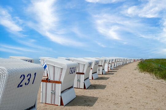 Many white beach chairs set up in a row on the beach in B&uuml;sum, Schleswig-Holstein.