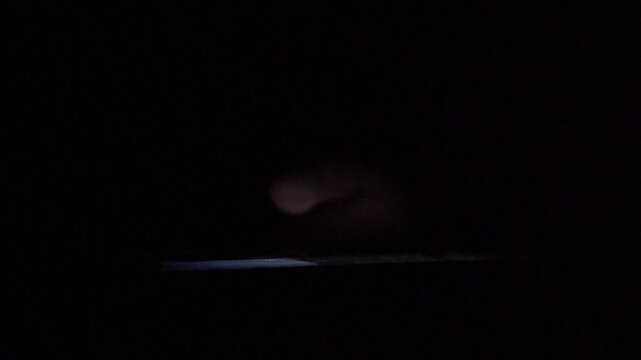 Man Scrolling Social Media on Smartphone at Night