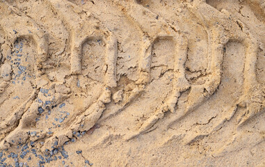Deep tractor tire tread imprinted in dry sand. Detailed tracks from heavy equipment or industrial vehicles at a construction site, excavation concept. © yaviki