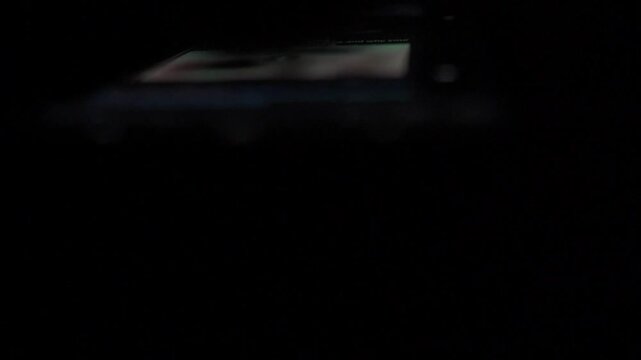 Man Scrolling Social Media on Smartphone at Night