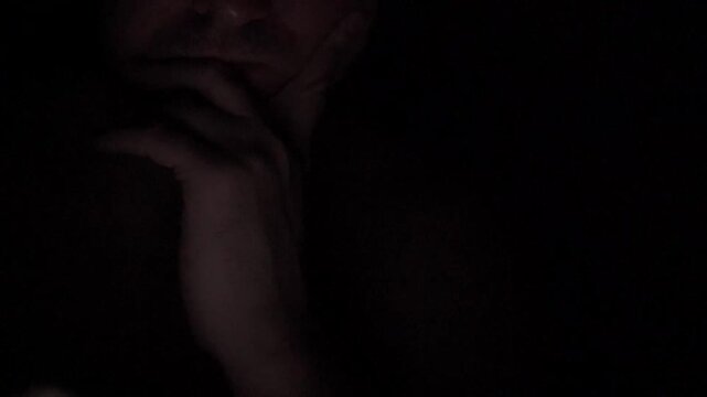 Man Scrolling Social Media on Smartphone at Night
