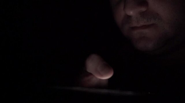 Man Scrolling Social Media on Smartphone at Night