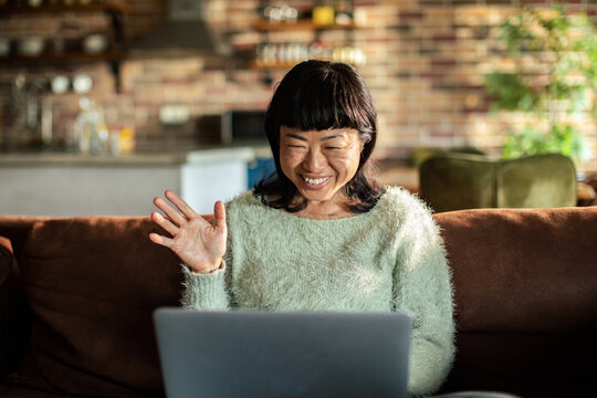 Smiling woman on video call with laptop at home