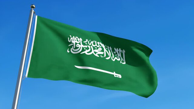 Saudi Arabian Flag Waving - The flag of Saudi Arabia waves against a bright blue sky. The green flag features the Shahada in white Arabic script above a white sword.