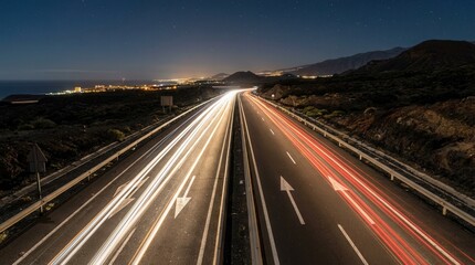 Obraz premium Night Highway Streaking Lights Across A Dark Landscape Under Starry Sky