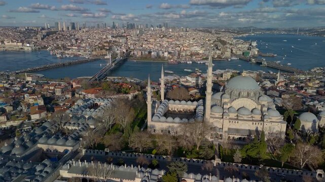Aerial drone view of the historic Golden Horn in Istanbul, showing the Suleymaniye Mosque, Galata Bridge and the Bosphorus. Galata Tower and Taksim Square in the distance.