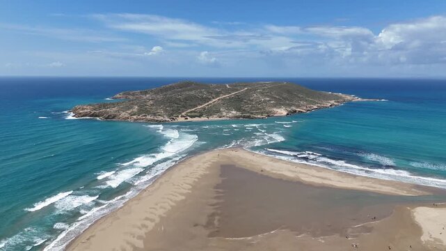 Aerial view of Prasonisi during the sea tide - the southmost point of Rhodos called the kiss of two seas, where waves of the Aegean and Mediterranean seas meet 