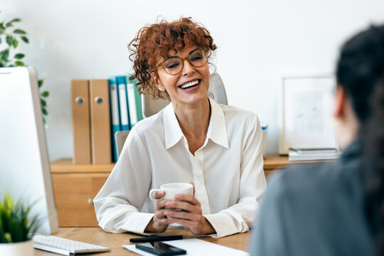 Cheerful businesswoman talking with her partner while working in the office
