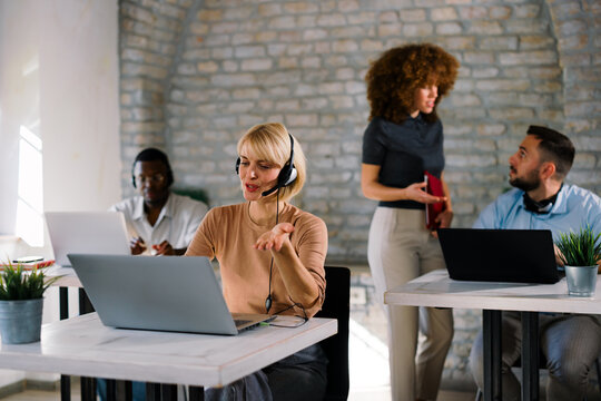 Customer support agent working with headset in office