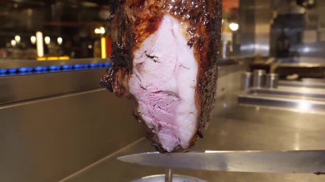 A close-up shot of a gaucho chef skillfully carving thin, succulent slices of fire-roasted picanha (top sirloin cap) from a large metal skewer. The meat features a perfectly seared crust and a tender,