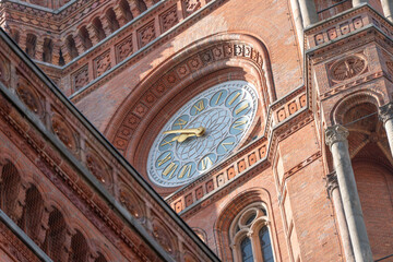 Obraz premium Detailed view of the clock on the Rotes Rathaus tower in Berlin. Ornamental brickwork surrounds the historic city hall clock face.