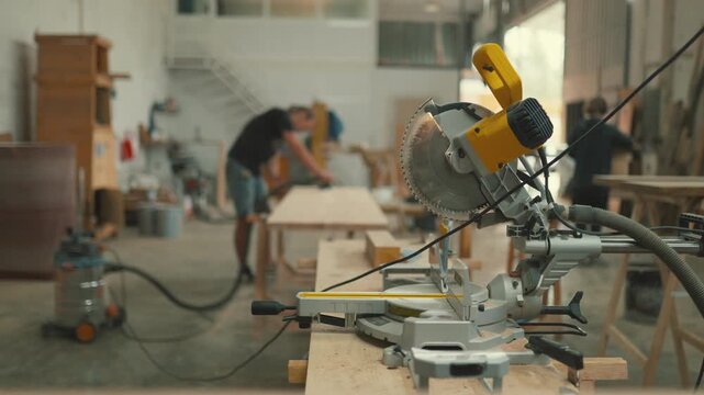 Compound miter saw in a busy carpentry workshop
