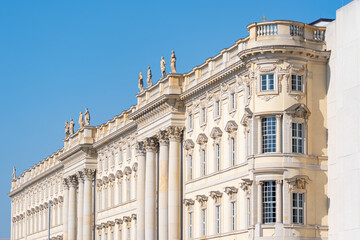 Fototapeta premium Elegant historic palace facade with columns and statues in Berlin. Classical European architecture under a bright blue sky.