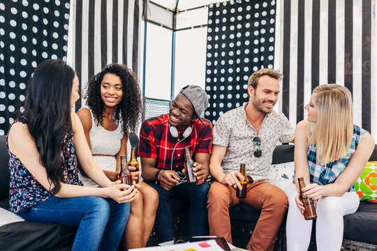 Friends chatting and drinking beer in cozy lounge