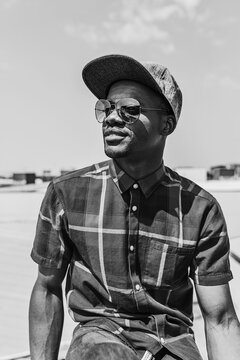 Black and white portrait of stylish black Man outdoors in sun