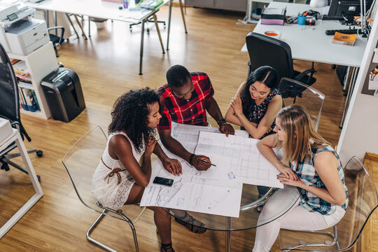 Team planning project around table in modern office