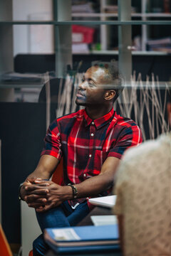 Young man in plaid shirt waiting in modern office lounge