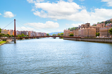 Obraz premium The Saône River in Lyon, red mast of the Passerelle du Palais de Justice on the left. The skyline of Vieux Lyon dominates the right bank, with the columns of the Palais de Justice