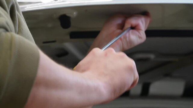 Body repair. A specialist repairs a dent on the car body without painting. Paintless Car Dent Repair. PDR. Process of paintless dent repair on car body. The mechanic at the auto shop with tools. 