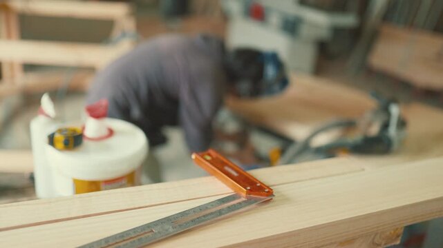 Carpentry workshop scene with a focus on measuring tools on a wooden plank