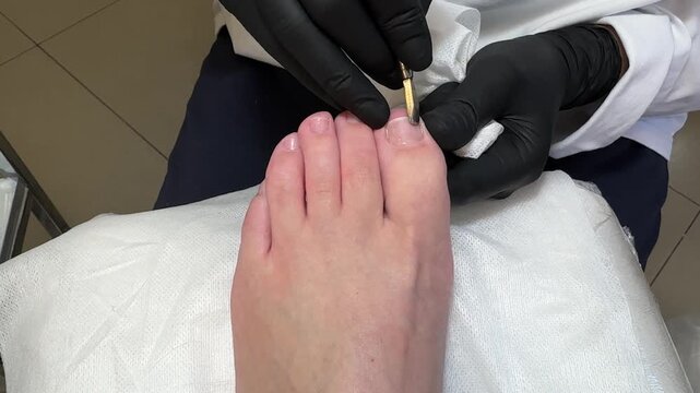 Pedicure podology salon beauty foot care cuticle procedure by specialist shows treatment with nippers on toes during a professional hygienic session.
