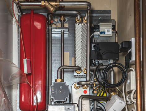 Gothenburg, Sweden - March 18 2026: Residential heating system with expansion tank pipes and control units in utility room.