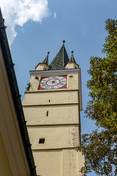 clock unfolds beneath the open sky across Soala, Romania, on the side of a building with a sky background