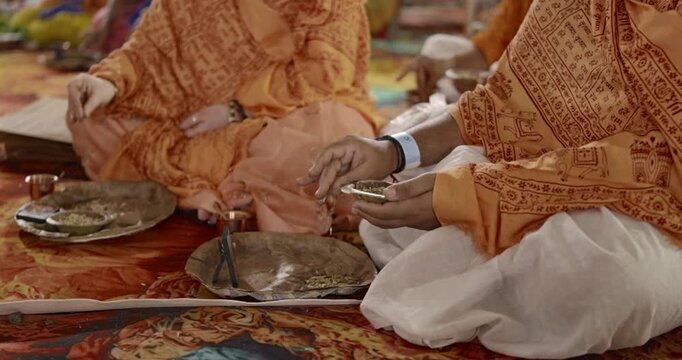 Close-up of aahuti being offered in hawan kund during pooja, showcasing flames, rituals, and sacred Hindu worship practices