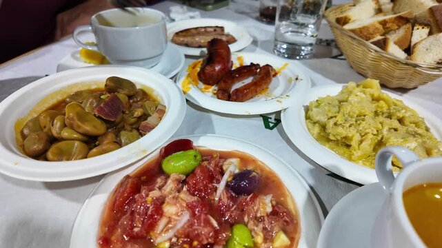 Traditional Spanish tapas spread on restaurant table in Murcia with stew tomato sauce grilled meat rice bread typical barraca dining experience